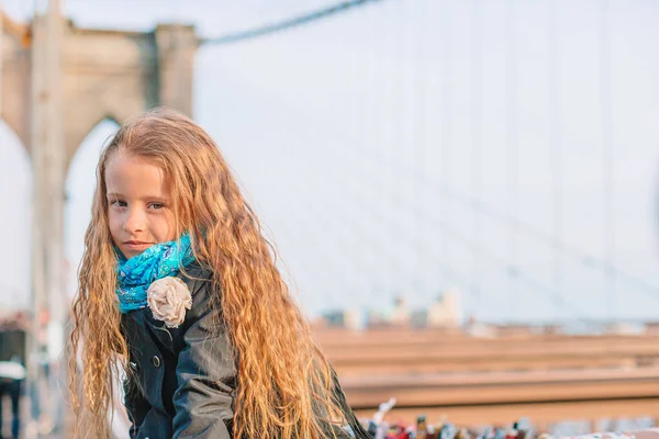 愛らしい女の子座っていますでブルックリン橋でニューヨーク — ストック写真