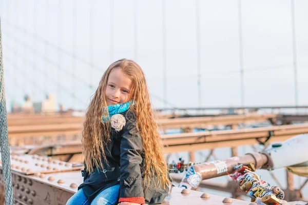 Adorable niñita sentada en el Puente de Brooklyn en Nueva York —  Fotos de Stock