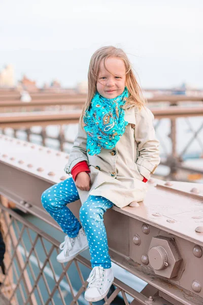 Adorable niñita sentada en el Puente de Brooklyn en Nueva York —  Fotos de Stock