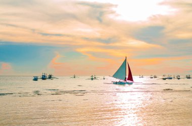 Boracay adasında gün batımına doğru yelkenli.