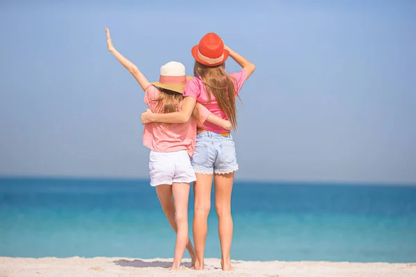 Lite glada roliga tjejer har mycket roligt på tropiska stranden leker tillsammans. — Stockfoto