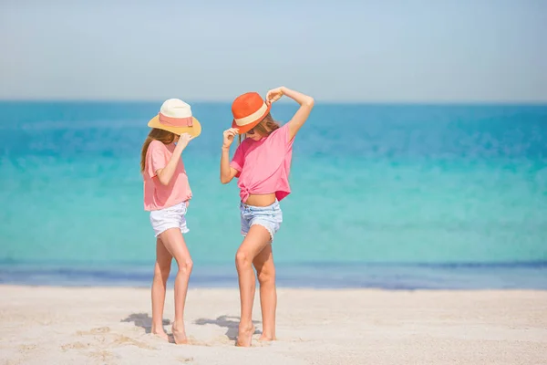 Little happy funny girls have a lot of fun at tropical beach playing together. — Stock Photo, Image