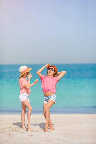 Mało szczęśliwe śmieszne dziewczyny mają dużo zabawy na tropikalnej plaży bawiąc się razem. — Zdjęcie stockowe