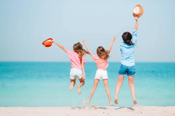 Söta små flickor och ung mor på tropisk vit strand — Stockfoto