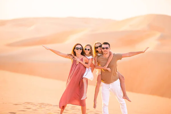Jeune famille de quatre personnes dans un grand désert de sable — Photo