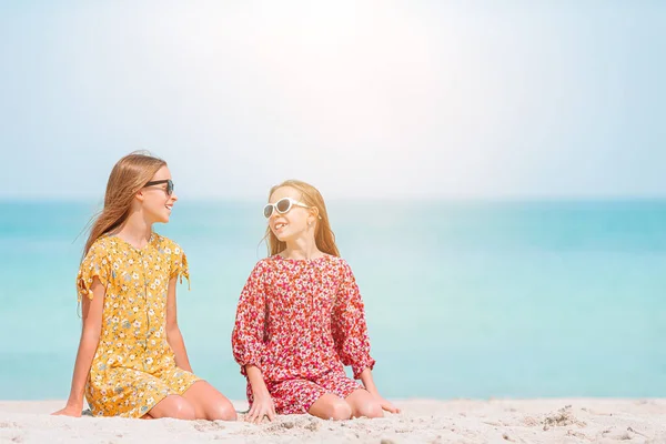 Kleine fröhliche lustige Mädchen haben viel Spaß am tropischen Strand beim gemeinsamen Spielen. — Stockfoto