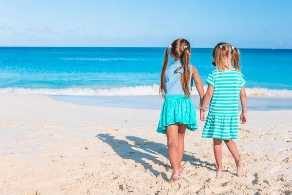 Lite glada roliga tjejer har mycket roligt på tropiska stranden leker tillsammans. — Stockfoto