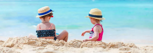 Двое детей делают песочный замок и веселятся на пляже — стоковое фото