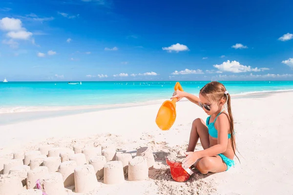 Liten flicka på tropisk vit strand gör sand slott — Stockfoto