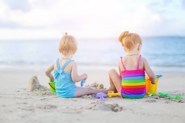 Dwoje dzieci robi zamek z piasku i bawi się na tropikalnej plaży — Zdjęcie stockowe