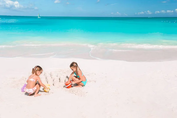 Két gyerek homokvárat csinál és jól érzik magukat a trópusi strandon. — Stock Fotó