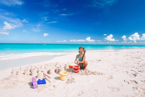 Kleines Mädchen am tropischen weißen Strand baut Sandburg — Stockfoto