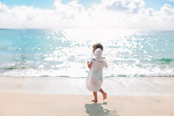 Schönes junges Mädchen trägt Engelsflügel am Strand — Stockfoto