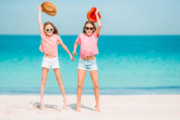 Lite glada roliga tjejer har mycket roligt på tropiska stranden leker tillsammans. — Stockfoto