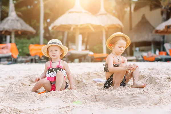 Two kids making sand castle and having fun at tropical beach — Stock Photo, Image