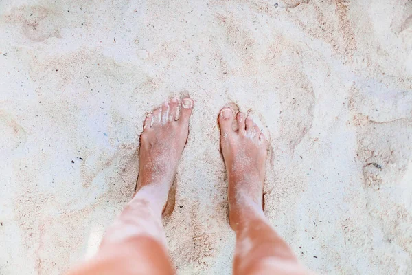 Młoda kobieta opalająca się na białej plaży. Nogi. — Zdjęcie stockowe