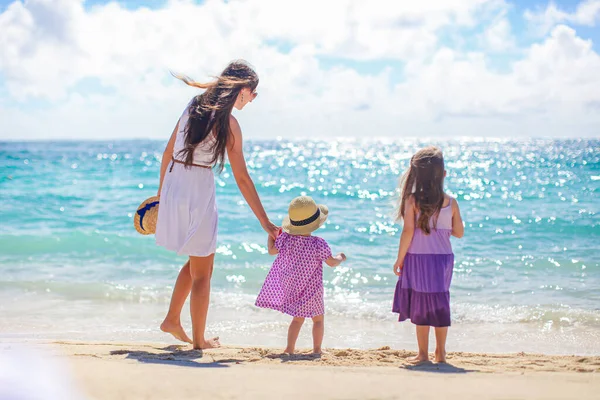 Söta små flickor och ung mor på tropisk vit strand — Stockfoto