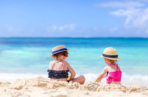 Dwoje dzieci robi zamek z piasku i bawi się na tropikalnej plaży — Zdjęcie stockowe