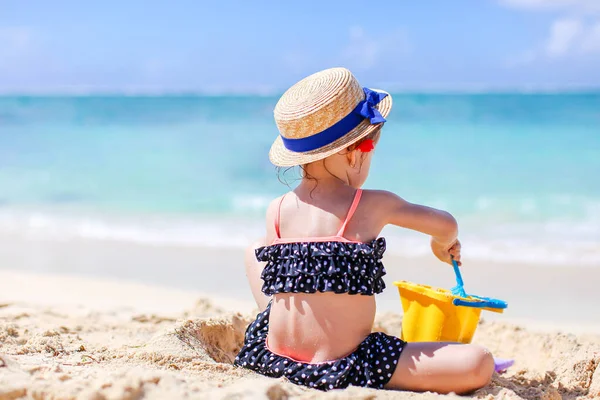 Klein meisje op tropisch wit strand maken zand kasteel — Stockfoto