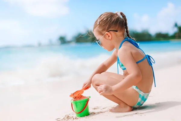 Little girl at tropical white beach making sand castle — Stock Photo, Image