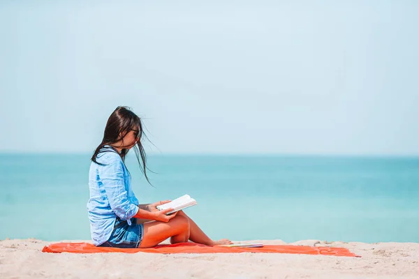 Young person reading book during tropical white beach — Stock Photo, Image