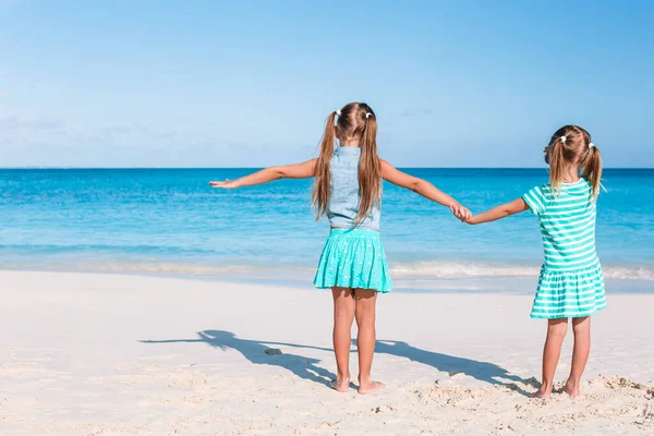 小さな幸せな面白い女の子は一緒に遊んで熱帯ビーチで多くの楽しみを持っています. — ストック写真