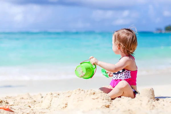 Menina na praia branca tropical fazendo castelo de areia — Fotografia de Stock