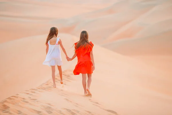Κορίτσια ανάμεσα σε αμμόλοφους στην έρημο Rub al-Khali στα Ηνωμένα Αραβικά Εμιράτα — Φωτογραφία Αρχείου