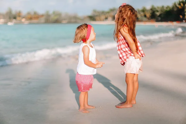 Pequeñas chicas divertidas felices tienen un montón de diversión en la playa tropical jugando juntos. —  Fotos de Stock
