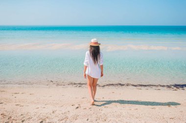 Plajda uzanan kadın yaz tatilinin tadını çıkarıyor ve denize bakıyor.