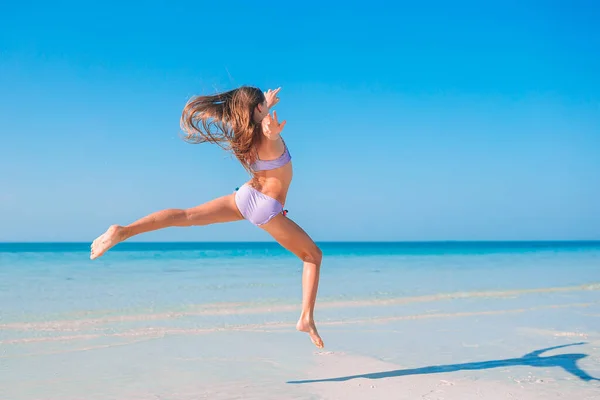 Aktives kleines Mädchen am Strand mit viel Spaß. — Stockfoto