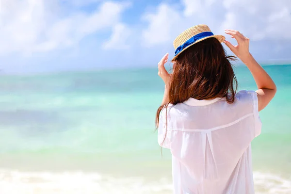 Mujer tendida en la playa disfrutando de vacaciones de verano mirando al mar —  Fotos de Stock