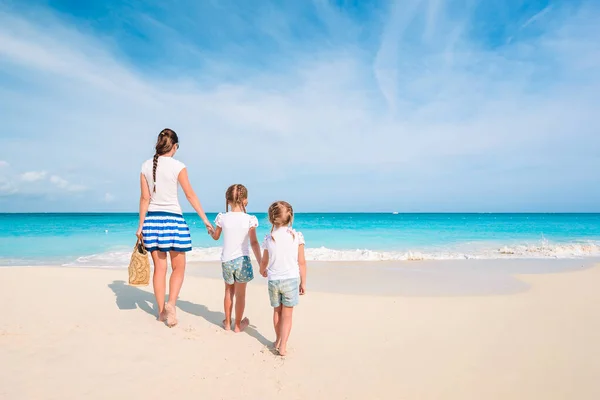 Schattige kleine meisjes en jonge moeder op tropisch wit strand — Stockfoto