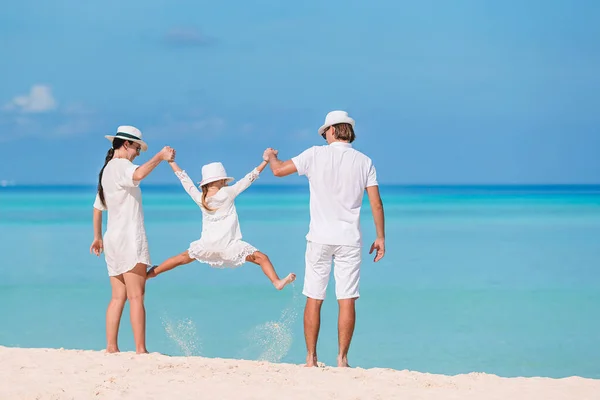 Üç kişilik mutlu bir aile sahilde birlikte eğleniyor. — Stok fotoğraf
