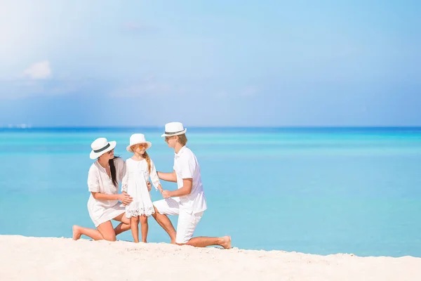 Família feliz de três se divertindo juntos na praia — Fotografia de Stock