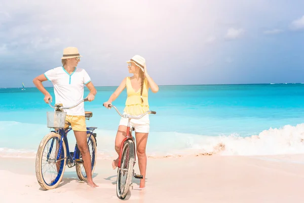 Happy family riding bicycles on the beach — Stock Photo, Image