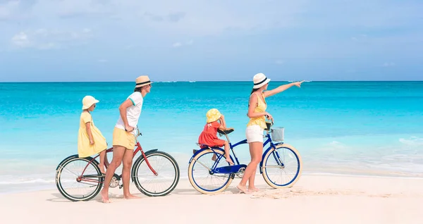 Familia con una bicicleta en la playa tropical — Foto de Stock