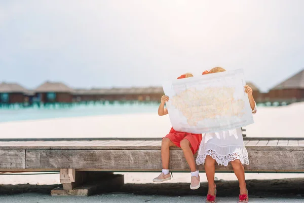 Kleine entzückende Mädchen mit großer Karte im Urlaub am tropischen Strand — Stockfoto