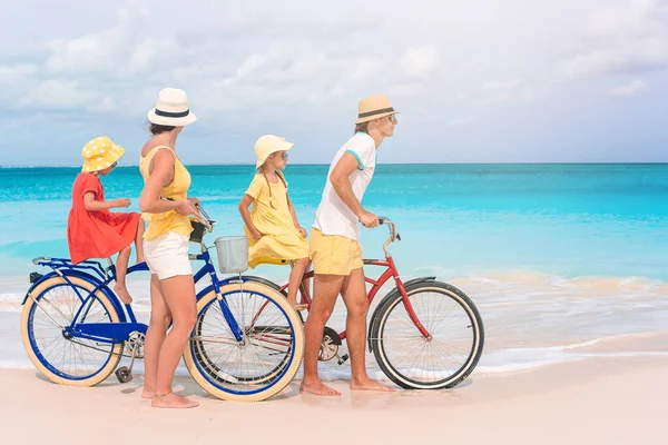 Familia con una bicicleta en la playa tropical — Foto de Stock