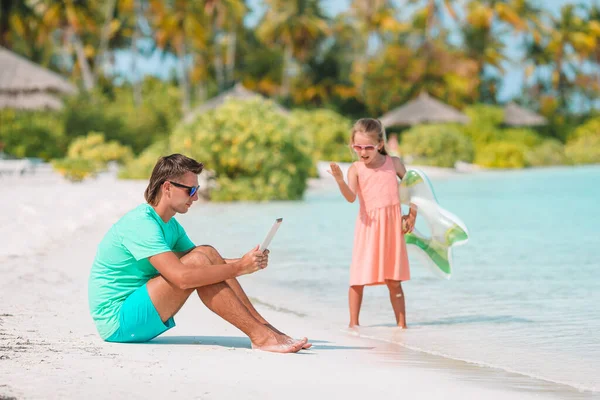 Traurige kleine Kinder warten darauf, dass ihr Papa mit dem Laptop schwimmt und Spaß am Strand hat — Stockfoto