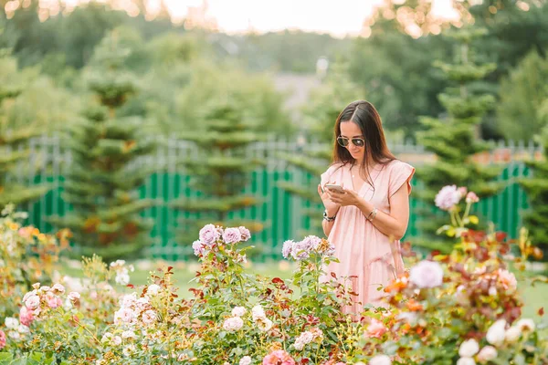 Jong meisje in een bloementuin tussen prachtige rozen. Rozengeur — Stockfoto