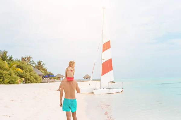 Маленька дівчинка і щасливий тато розважаються під час пляжних канікул — стокове фото