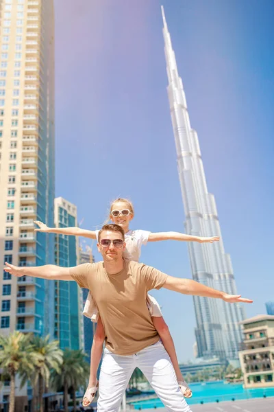 Happy family walking in Dubai with skyscrapers in the background. — Stock Photo, Image