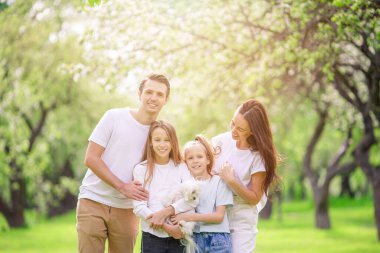 Güzel bir bahar gününde kiraz bahçesinde sevimli bir aile.