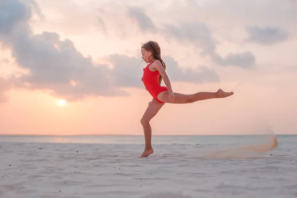 Adorable niña feliz en la playa blanca al atardecer. —  Fotos de Stock