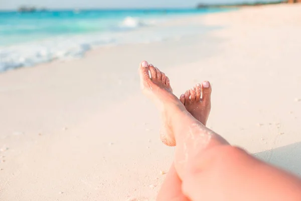 Piedi delle donne sulla spiaggia di sabbia bianca in acque poco profonde — Foto Stock