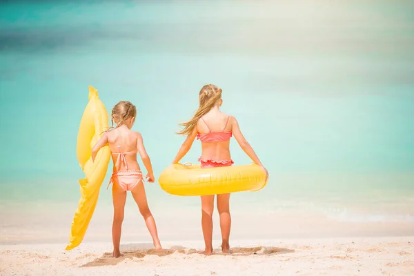 Kleine blije grappige meisjes hebben veel plezier op tropische strand spelen samen. Zonnige dag met regen in de zee — Stockfoto