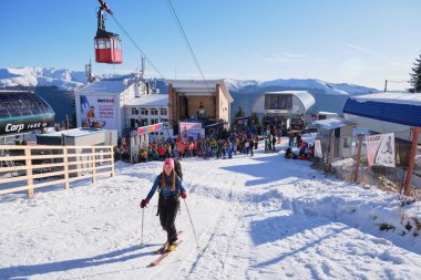 Sinaia, Romanya - 15 Aralık 2019: Cota 1400, Romanya 'nın Sinaia kayak sahasındaki kalabalık kaldırma hatlarında kayak yapan kız, kış mevsiminin başında sabahın erken saatlerinde.