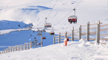 Sinaia, Romanya - 16 Aralık 2019: Güneşli bir kış gününde Romanya 'nın Sinaia kayak sahasının Cota 2000 kentinde başkanlık ve ahşap çitler.