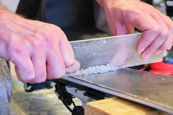 Plexi kazıyıcı kullanarak kayak tabanından fazla balmumu çıkarmak - balmumuna odaklanmak. Kayak akordu ve bakım konseptini fırçalamadan önce kayağın tabanının hazırlanması.